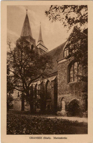 Historisches Gebäude mit zwei Türmen und Bäumen im Vordergrund.